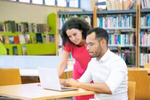 man and woman looking at laptop screen